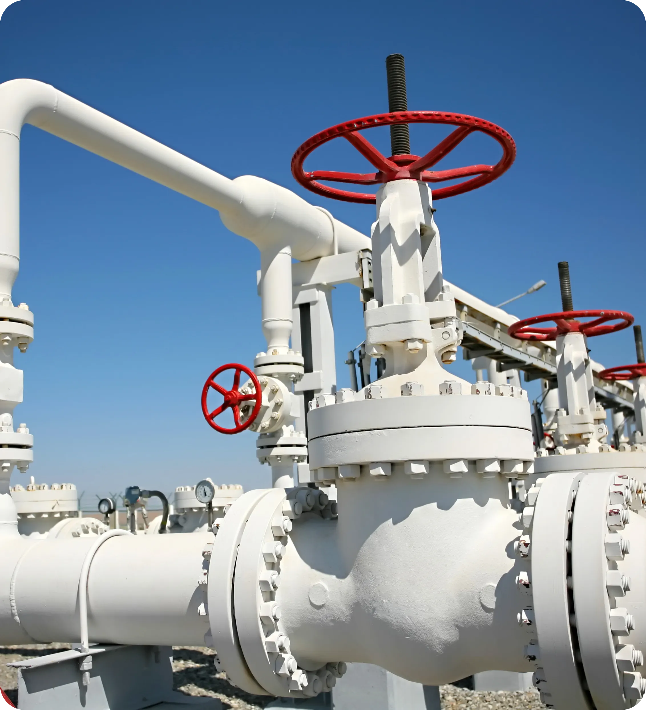 A white pipe with red handles and valves.