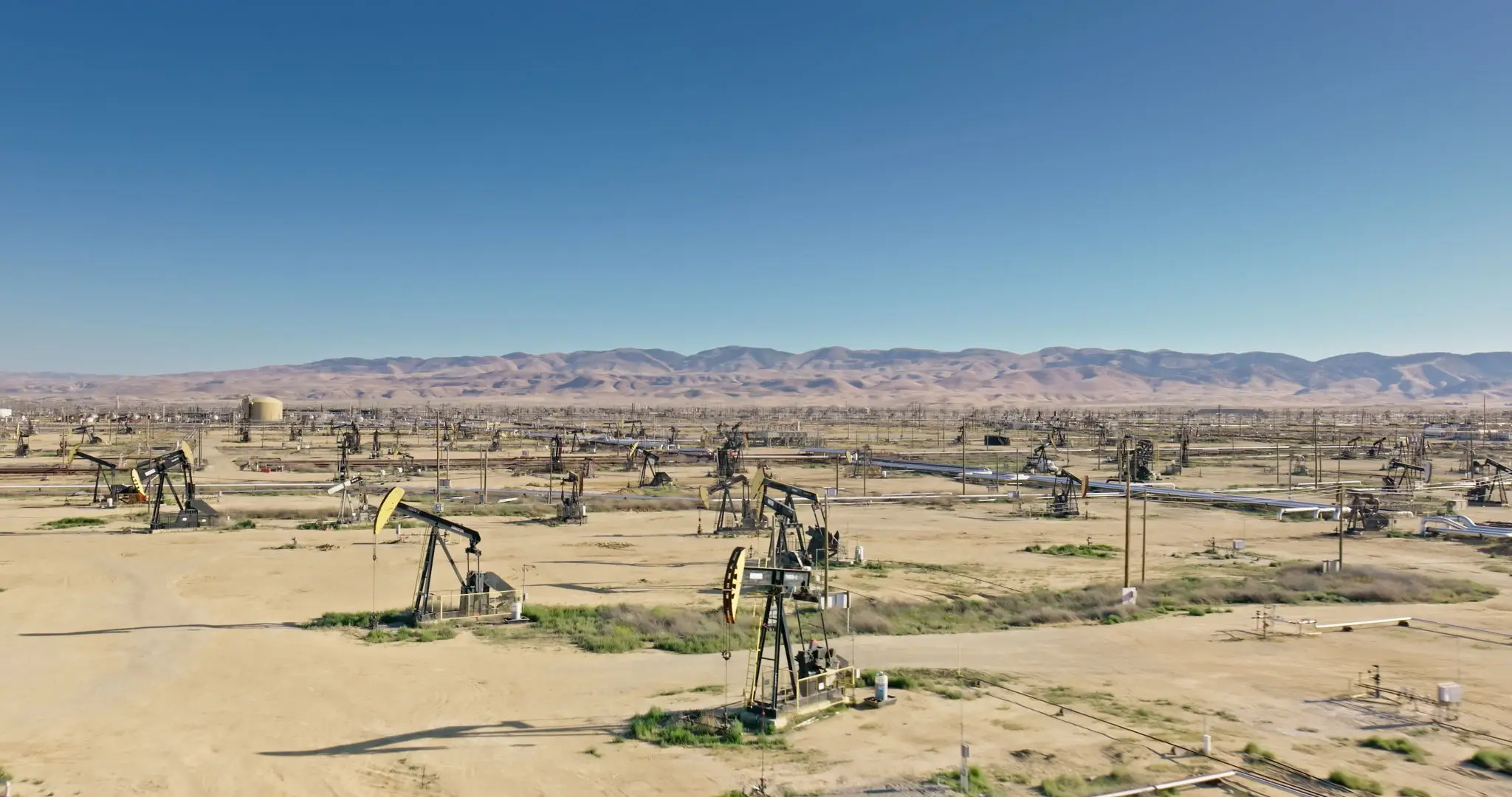 gettyimages-2156736565-2048x2048 A field with many oil pumps in the middle of it.
